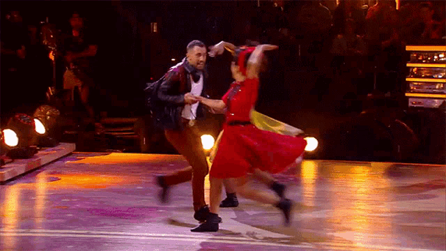 a man and a woman are dancing on a stage in front of a crowd