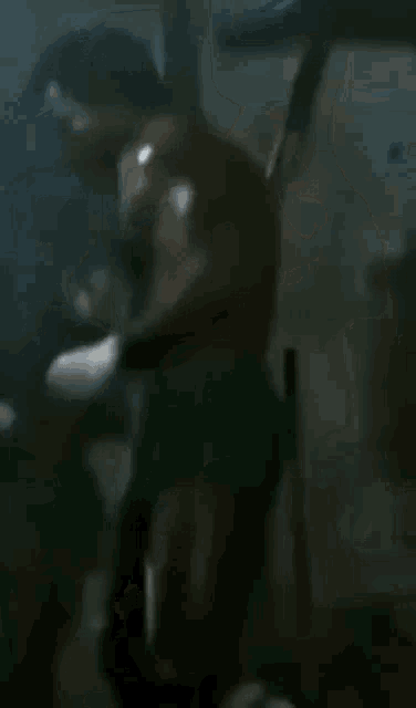 a man is boxing in a dark room with a microphone .