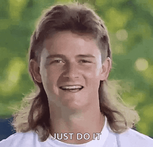 a man with a mullet and a white shirt is smiling and says just do it