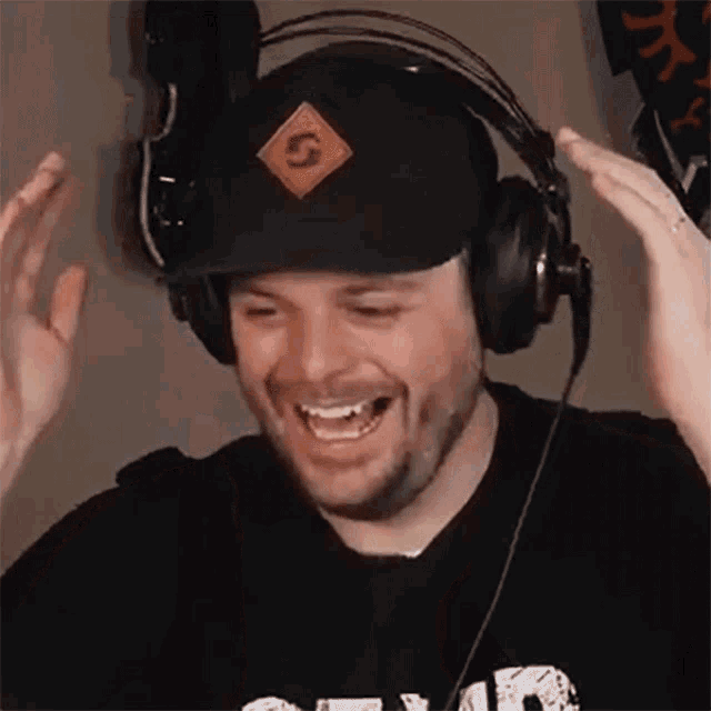 a man wearing headphones and a hat has the letter s on his hat