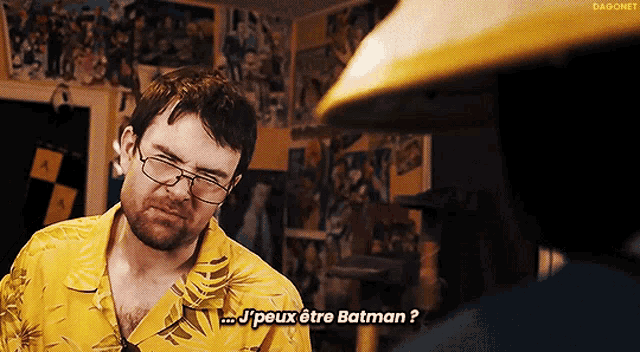 a man wearing glasses and a yellow shirt says j peux être batman