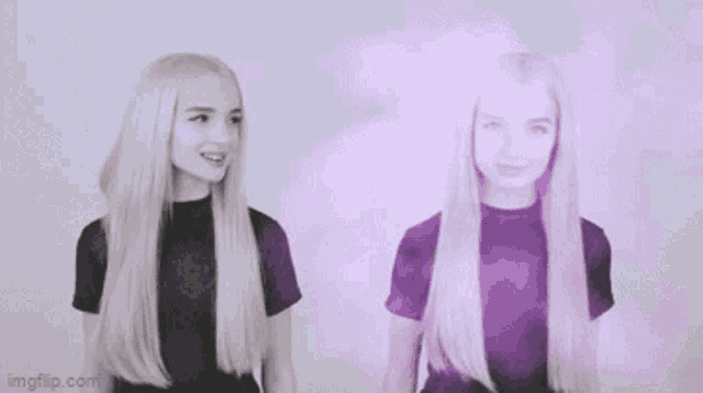 two blonde women with long hair are standing next to each other and talking to each other .