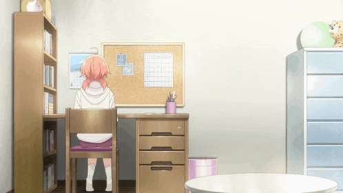 a girl sits at a desk with a calendar on the wall that says february