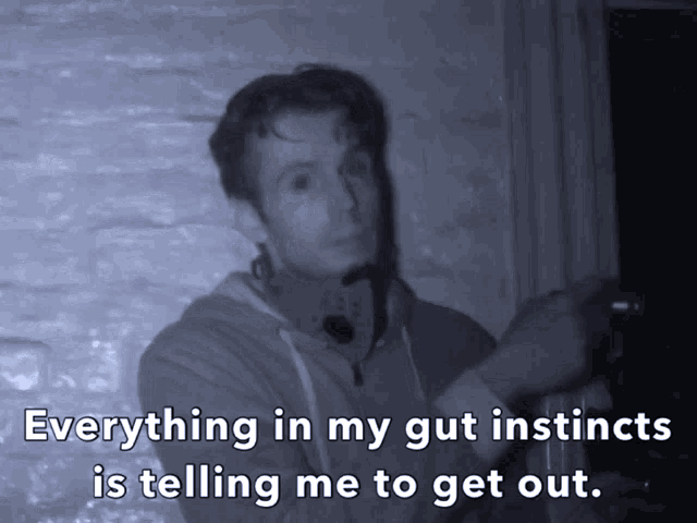 a man in a dark room with the words " everything in my gut instincts is telling me to get out "