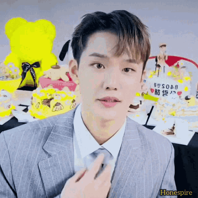 a man in a suit and tie is standing in front of a cake that says honespire