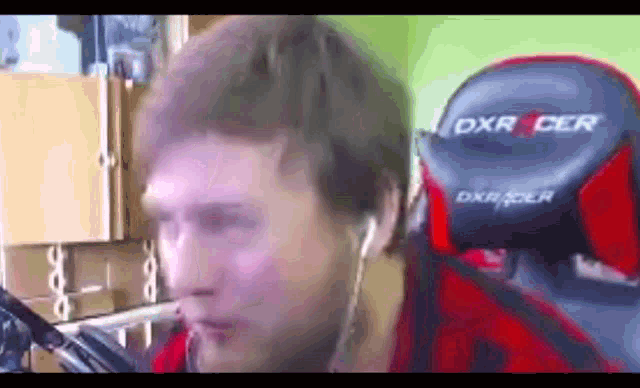 a man is wearing headphones and sitting in a dxr racer chair