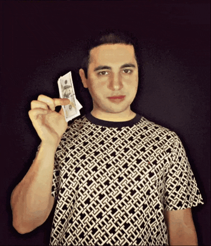 a man in a black and white shirt is holding a stack of twenty dollar bills