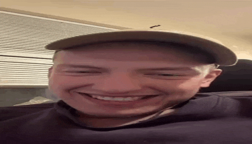 a man wearing a hat is smiling for the camera .