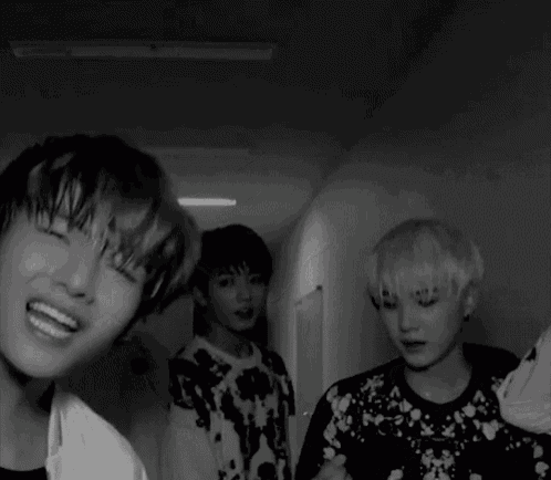 a group of young men are standing in a room and one of them is making a funny face