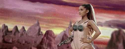 a woman in a corset is standing in front of a mountain range holding a gun .