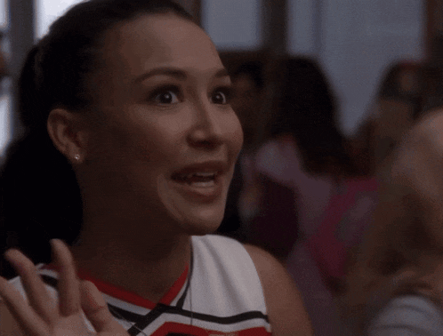 a cheerleader is making a surprised face while wearing a red white and black uniform