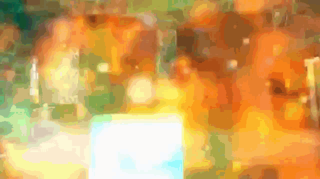a blurred image of a bottle with a yellow background