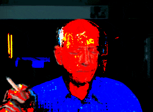 a man in a blue shirt is smoking a cigarette and has a red head