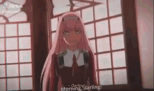zero two from darling in the franxx is standing in front of a window .