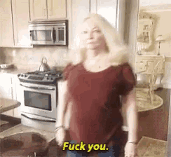a woman in a kitchen says fuck you in yellow letters