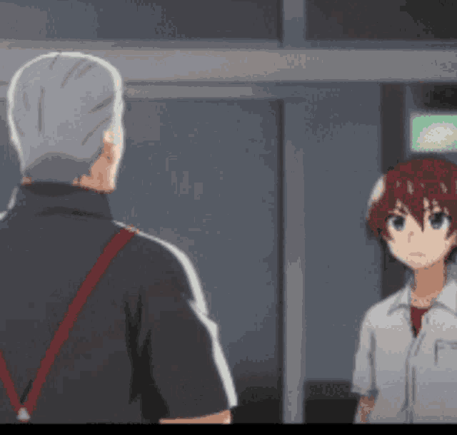 a man and a boy are standing next to each other in a room and talking .