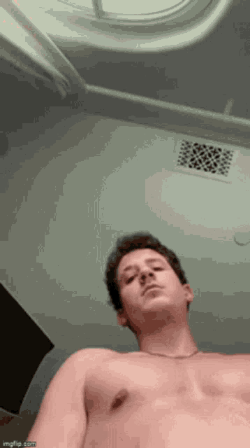 a man without a shirt is looking up at the ceiling