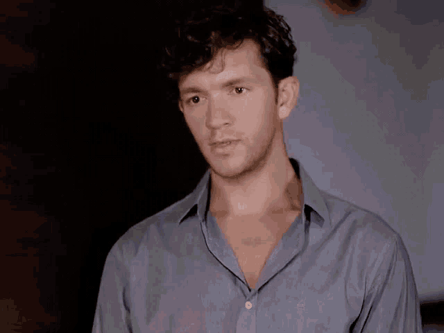 a man wearing a blue shirt with the letter e on the collar