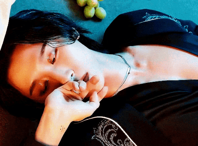 a woman with a ring on her finger laying on the floor