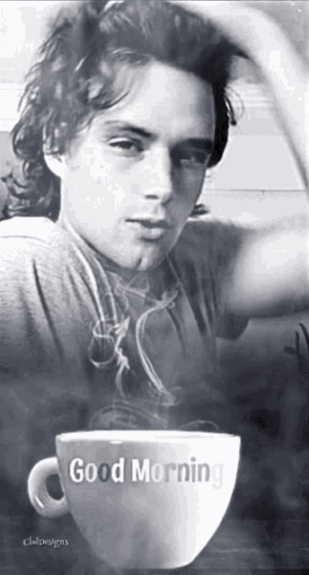 a black and white photo of a man and a cup of coffee that says good morning