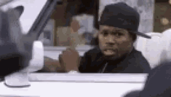 a man in a black hat is sitting in the driver 's seat of a white car .
