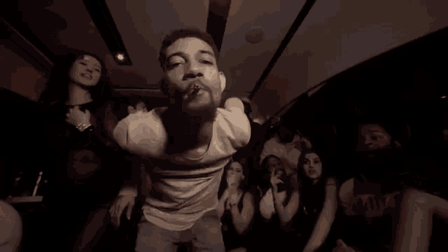 a man is dancing in a crowd of people at a party .