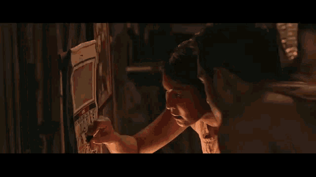a man and a woman are looking at a calendar in a dark room .