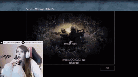 a woman is sitting in front of a cs go screen