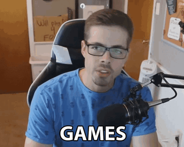 a man sitting in front of a microphone with the word games below him