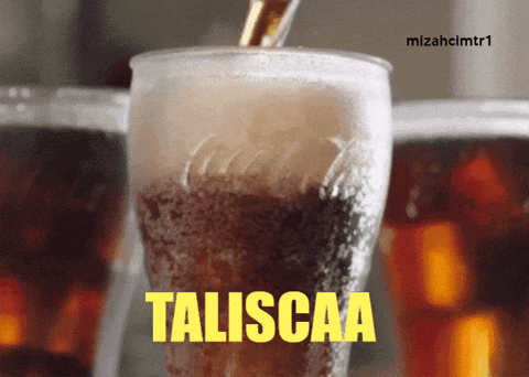 a glass of taliscaa is being poured into a cup