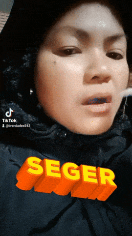 a woman is wearing a black hijab and has the word seger in orange letters