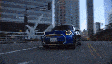 a blue mini cooper is driving down the street