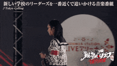 a woman stands in front of a sign that says live
