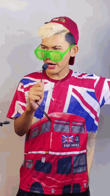 a man wearing a british flag shirt is holding a microphone in his mouth