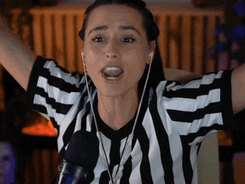 a woman wearing a black and white striped shirt with a microphone in front of her