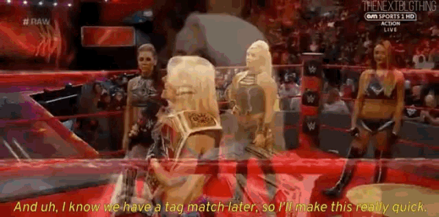 a group of women are standing in a wrestling ring and one of them is talking