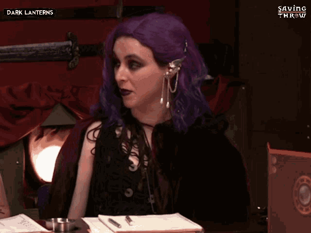 a woman with purple hair is sitting at a table and says i did n't have any issues