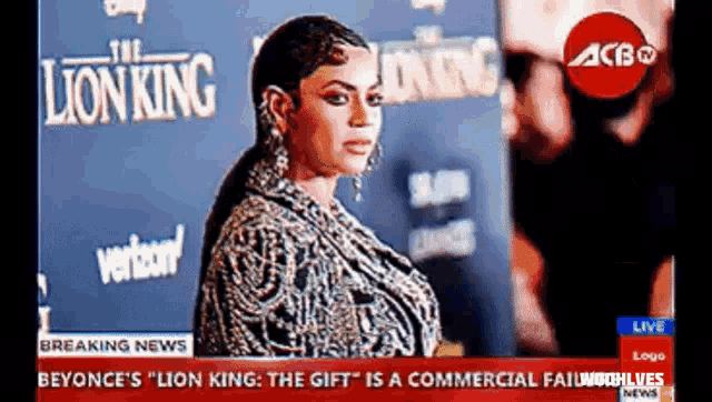 a woman is standing in front of a sign that says the lion king on it