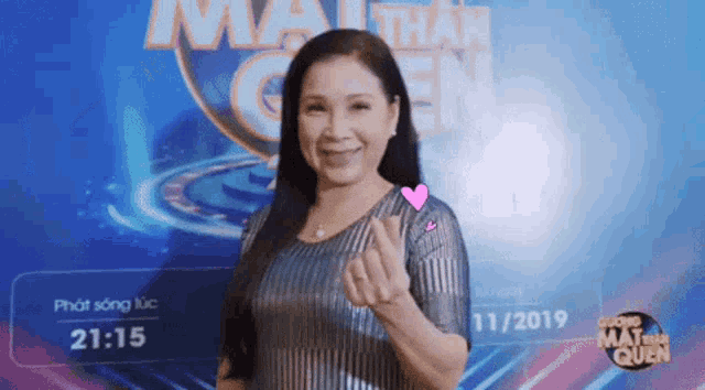 a woman stands in front of a sign that says mat than quen