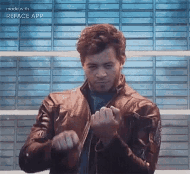a man in a leather jacket is making a funny face while standing in front of a wall .