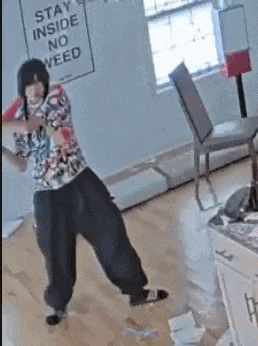 a person standing in a room with a sign that says stay inside no weed