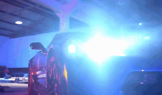a car 's headlights are shining brightly in the dark