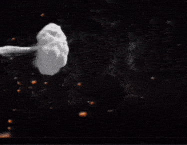 a yellow flower is surrounded by fire and smoke on a black background
