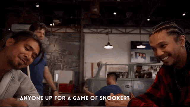 a group of men are playing a game of snooker and one of them is asking anyone up for a game of snooker