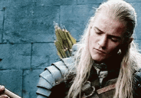 a man with long blonde hair is wearing armor and holding a sword .