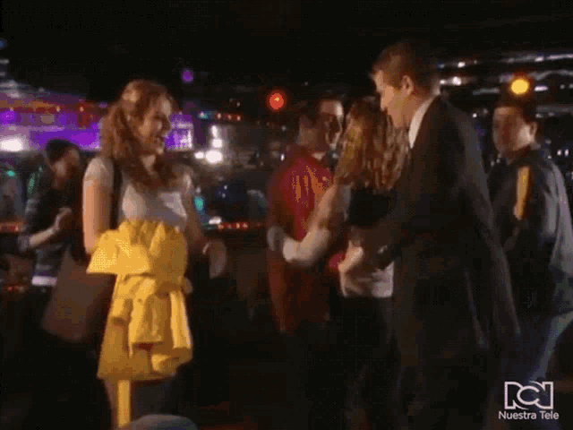 a group of people dancing in a club with nuestra tele written on the bottom of the screen
