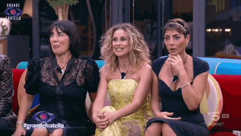 three women sitting on a couch with the words grande fratello on the screen