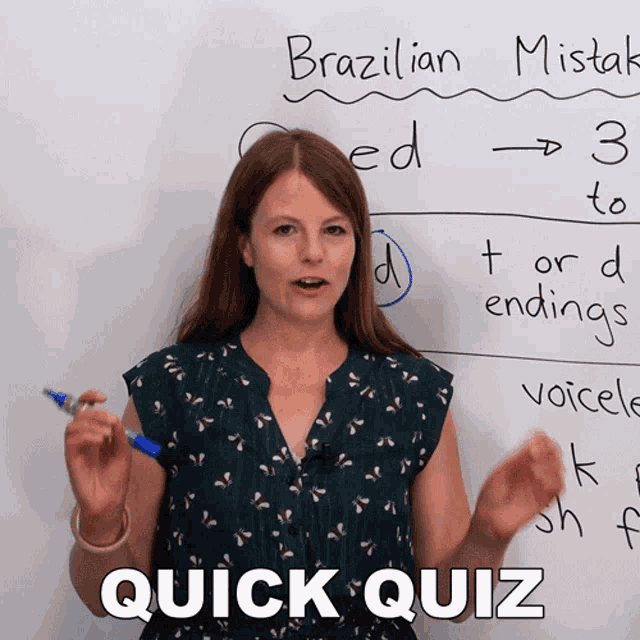 a woman stands in front of a white board with brazilian mistakes written in marker
