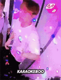 a man in a white shirt is standing in front of a karaoke boo sign ..