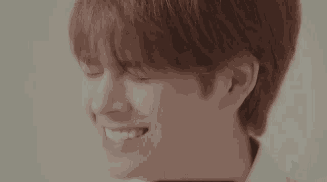 a close up of a person 's face with their eyes closed and a smile on their face .